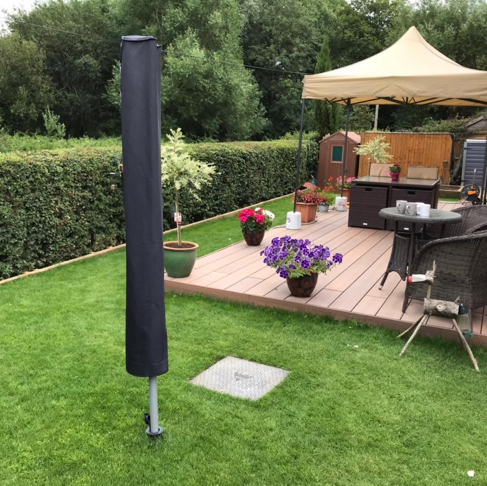 Composite decking with potted flowers, garden furniture and a gazebo on the lawn