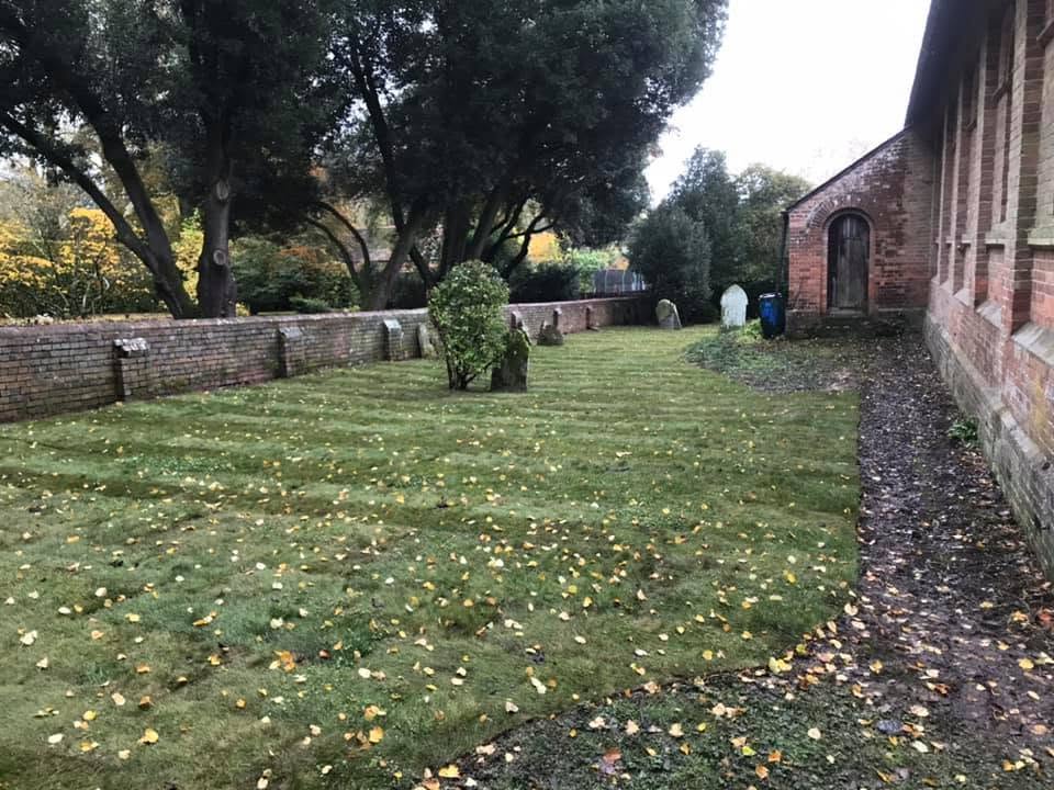 The same grounds cleared, with a neatly mown striped lawn beside the brick building