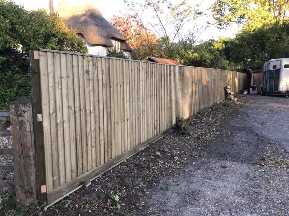 Closeboard fence on gravel boards running the length of a driveway